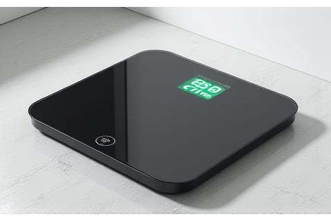 A modern smart body composition scale on a bathroom floor, displaying metrics.
